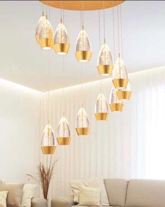 Cluster of gold crystal teardrop pendant lights hung above a staircase